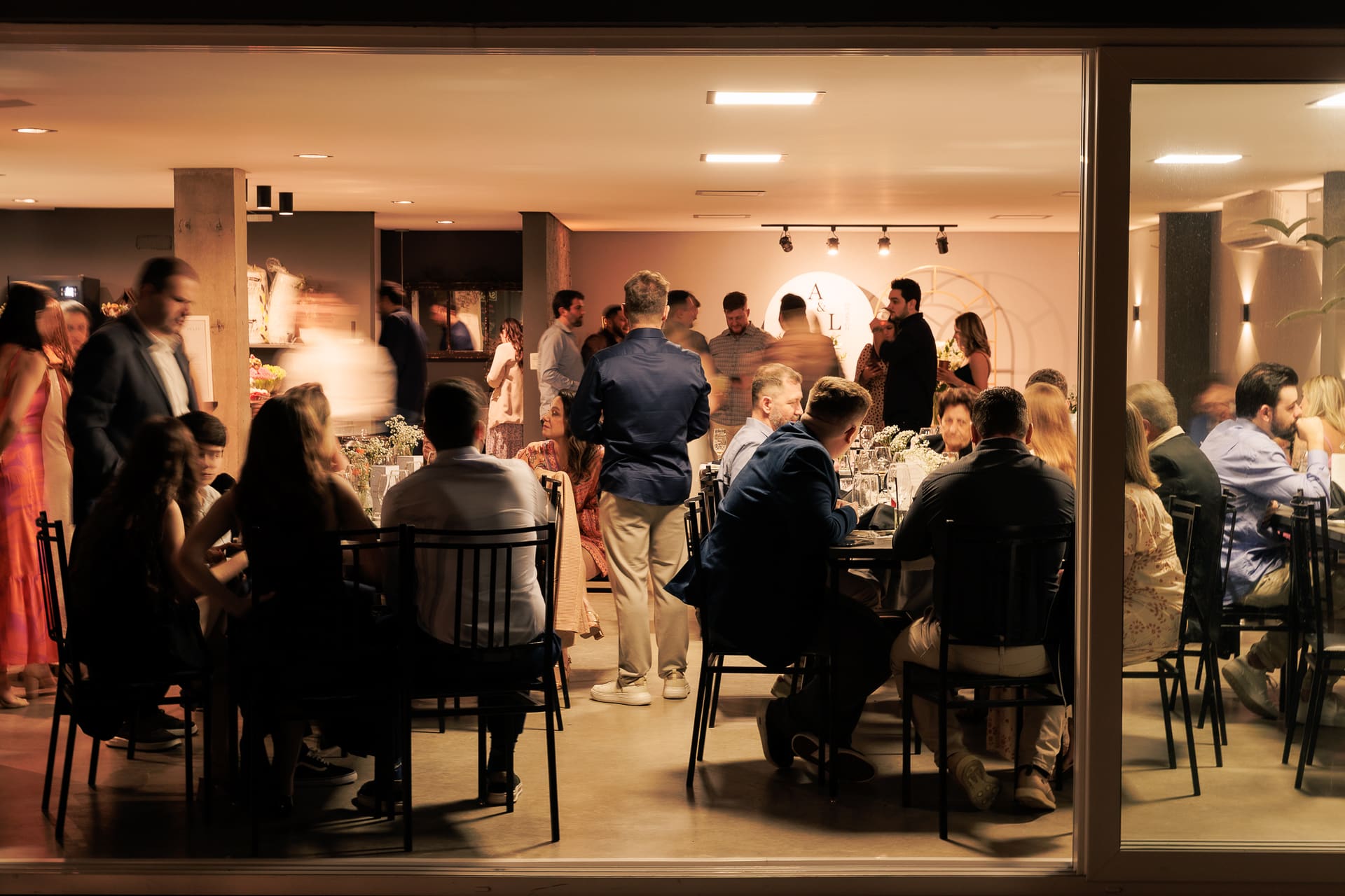Convidados reunidos no jantar de um casamento com música ao vivo de AQUINO