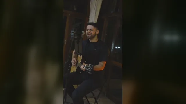 AQUINO cantando e tocando violão no vídeo Por Você, do Barão Vermelho