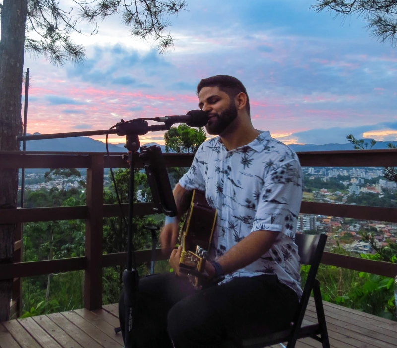 Foto profissional do músico Aquino com sua guitarra elétrica, demonstrando versatilidade de repertório para eventos.